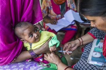 Area: Chandmari Juggi, Vijaynagar District: Ghaziabad, State: Uttar Pradesh Country: India, 22nd March 2017 . An ANM (Auxiliary Nurse Midwife) administers polio drops and vaccination to pregnant women and children at an Angnawadi in the Chandmari Juggi. 27-year-old Naazma Begum along with her husband Mohhammed Avrakh reside in a 100 sq.feet plot of land covered by blue and yellow plastic supported by bamboo sticks. In order to survive Naazma picks rags from garbage dumps and construction sites, sometimes travelling around 8 to 10 kilometers a day. Typically her day starts at 4:00 am, and sometimes can extend till late evenings. After picking useful items out of garbage she comes back to her slum colony and sorts out the various pieces of junk collected. Plastic, metals, glass and other items are separated and sold. Children, young and old participate in this activity. The sorted items would then be sold to a Kabadi Wala ( Wholesale Junk Shop). On certain days Naazma does not go for her morning rounds of rag picking. This does affects her household economically. Her husband a magician doing shows for a living does not have a steady stream of income. In spite of the circumstances Naazma on these mornings goes house to house motivating young mothers from her community to take their children for routine immunization sessions organized in her locality by the National Health Mission. An inspiration to many, Naazma sometimes has tough time convincing her friends to take their children. Excuses ranging from, We dont have time, the child will get fever  are common in her community. Naazma patiently explains the dangers caused due to lack of vaccination and its necessity in todays life to every household. Her effort along with the support of Community Mobilization Coordinator and Block Mobilization Coordinator has led to a massive increase in the children immunized in Vijaynagar Ghaziabad. Photographer: UNICEF India/2017/Prashanth Vish