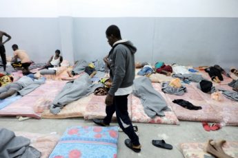 Refugees and migrants sleep on the floor at Tariq al-Sikka detention facility in Tripoli, Libya.