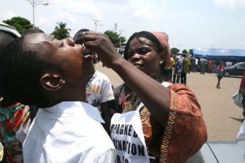 A woman in the Democratic Republic of Congo (DRC) administers a polio vaccine in Commune de Ndjili, Kinshasa.