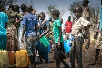 People take the opportunity to collect much needed water after a water truck gets stuck in the mud in Palorinya refugee camp, Uganda.