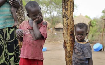 six-year-old South Sudanese refugee Santo, left, stands with his brother in Bidi Bidi camp, northern Uganda.