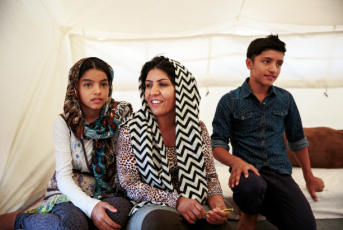 Shakila, center, fled Afghanistan with her kids, Sonia and Arash. Cash from Mercy Corps is helping them meet their urgent needs while living in Greece.